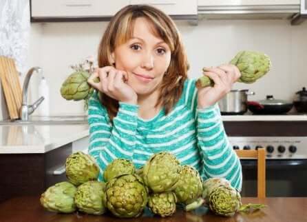 Donna con in mano due carciofi.