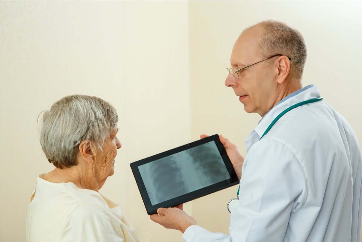 Medico che illustra radiografia a una signora.