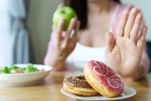 Donna che rifiuta ciambelle a colazione per perdere peso senza dieta.