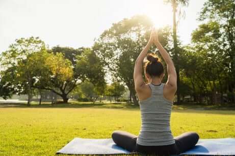 Ragazza che pratica yoga in un prato.