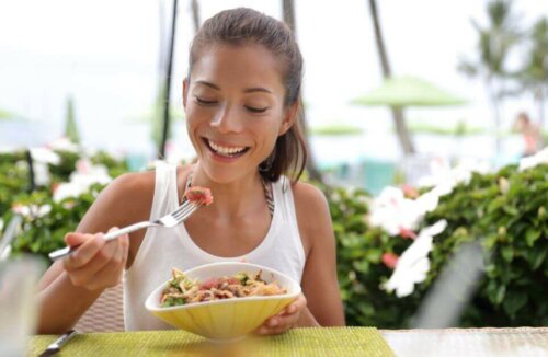 Ragazza che mangia insalata con tonno.