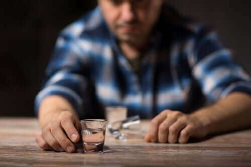 Uomo che beve alcolici al bancone.