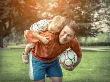 Uomo gioca a pallone con il figlio.