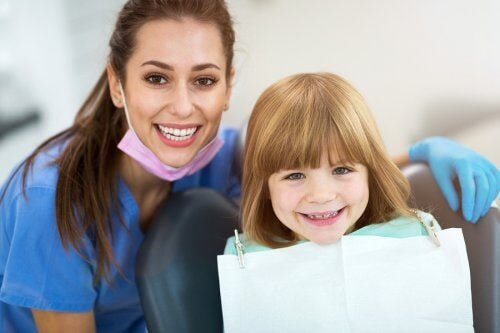 Dentista e bambina sorridenti.