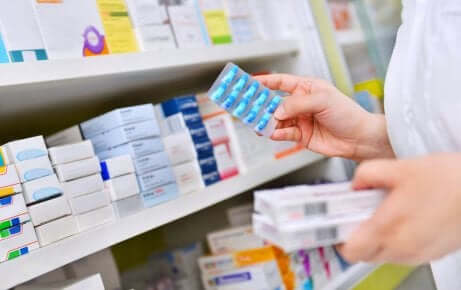 Farmacista e scaffale dei medicinali.