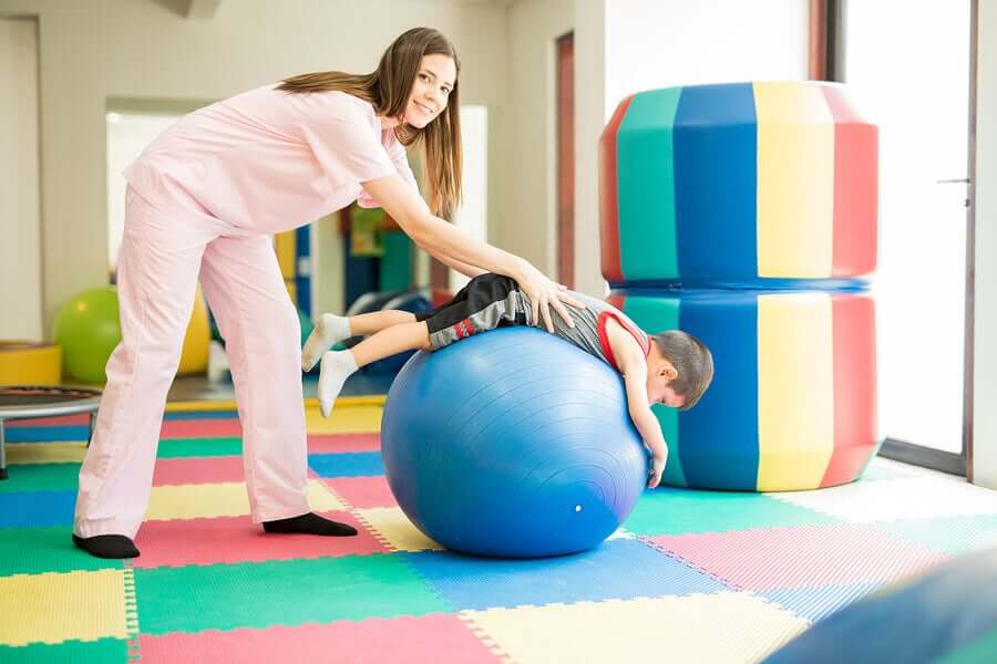 Fisioterapista fa esercizi con un bambino.