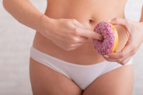 Ragazza con dito dentro la ciambella.