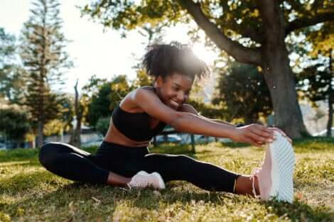 Ragazza esegue lo stretching per la corsa sul prato.