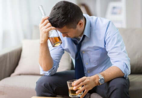 Assumere alcol a stomaco vuoto: uomo che beve un alcolico.
