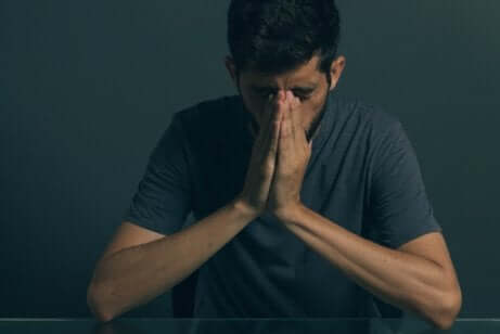 Uomo depresso con mani giunte.