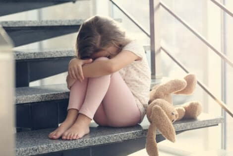 Spiegare la morte ai bambini: bambina triste con peluche.