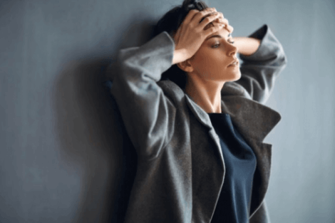 Donna che si tiene la testa.