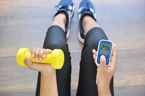 Sport e diabete: donna con pesini e misuratore di glicemia.