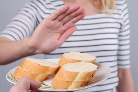 Miti sul glutine e donna rifiuta piatto con fette di pane.