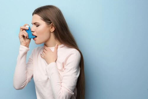 Donna che usa un inalatore per l'asma.