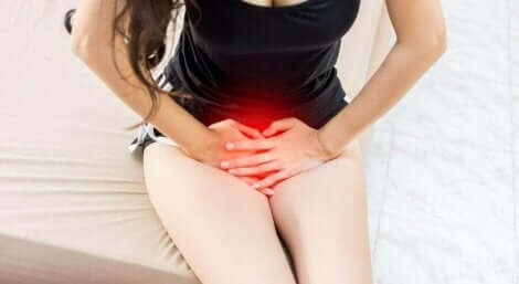 Ragazza con mani sul basso ventre.