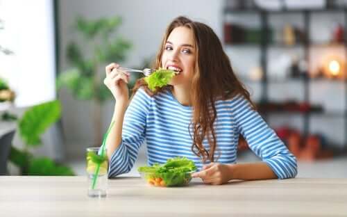 Ragazza mangia insalata e altri trucchi per mangiare meno.