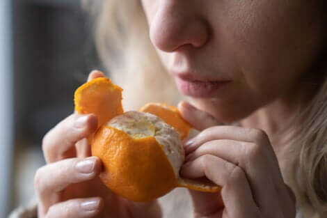 Donna annusa mandarino.