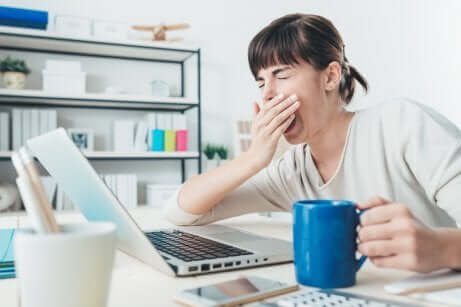 Donna che sbadiglia davanti al computer.