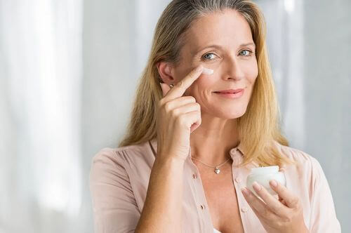 Donna che usa una crema antietà per la cura della pelle.