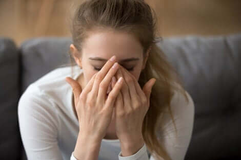 Ragazza preoccupata con le mani sul viso.