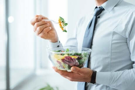 Uomo che mangia un'insalata.