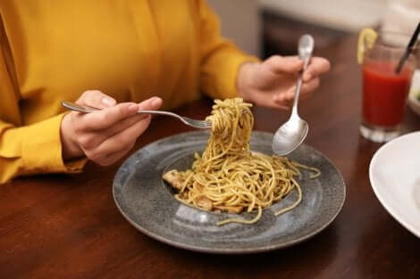 Donna che mangia un piatto di spaghetti.