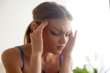 Donna con mal di testa a causa degli ormoni.