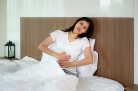 Donna dolore pancia nel letto.