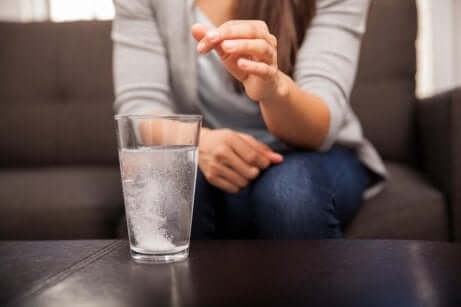 Ragazza scioglie aspirina nell'acqua.