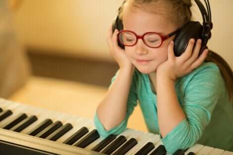 Bambina al piano con le cuffie.