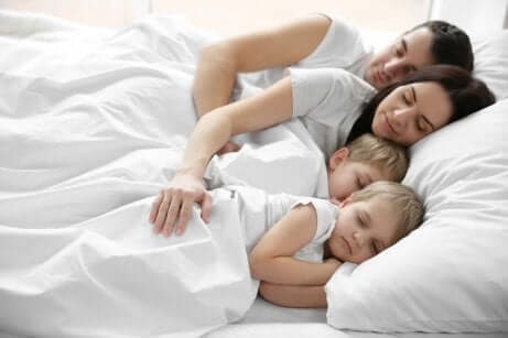 Gemelli dormono nel lettone con mamma e papà.