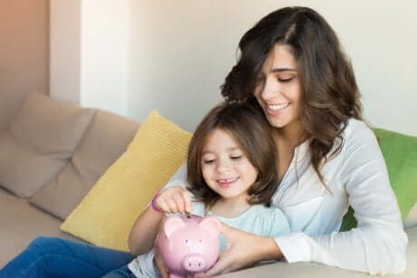 Madre e bambina con salvadanaio.