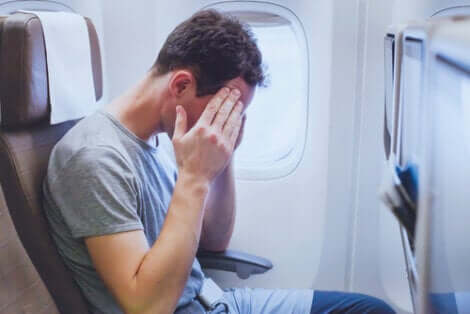 Uomo che soffre di stress e malessere in aereo.