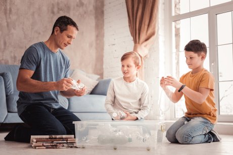 Padre e figli separano la plastica dal cartone.
