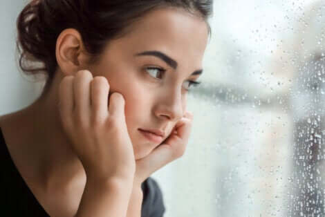 ragazza pensierosa e gocce di pioggia sul vetro.