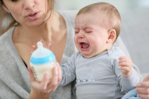 Carie da biberon e bambino che piange rifiutando il biberon.