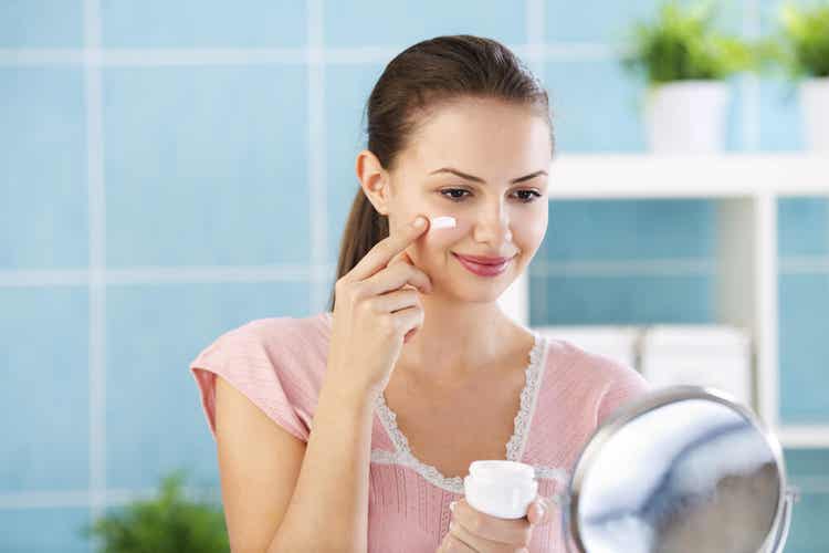 Ragazza applica crema idratante sul viso.
