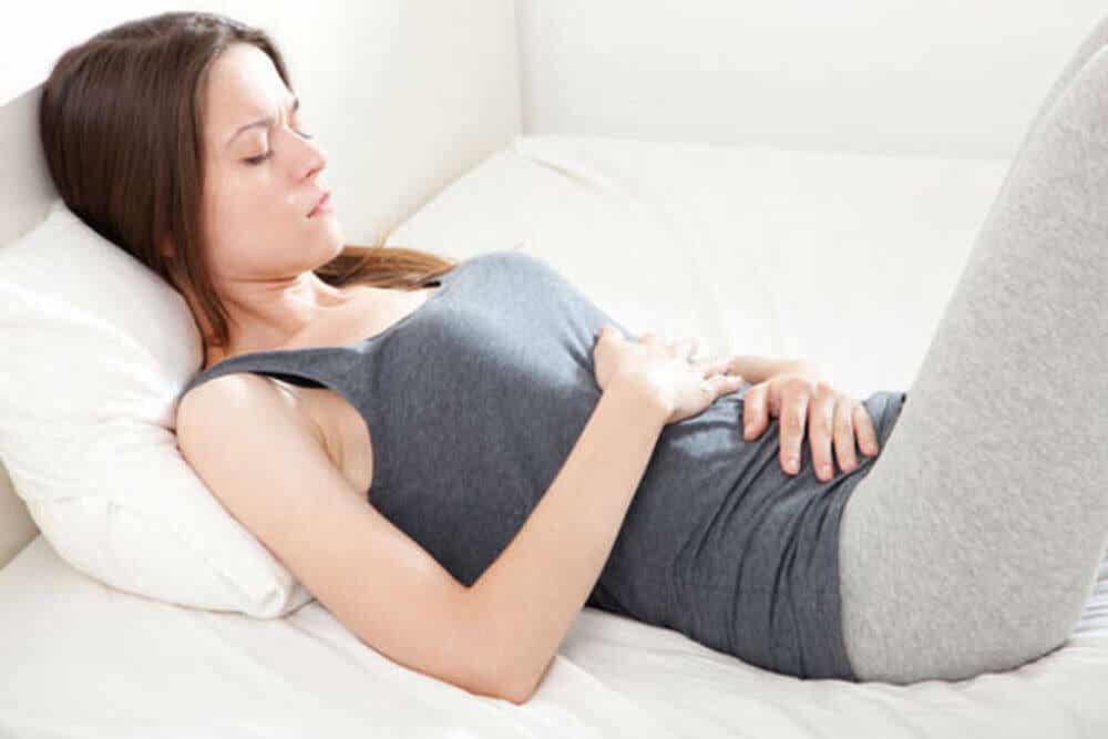 Donna a letto con influenza intestinale.