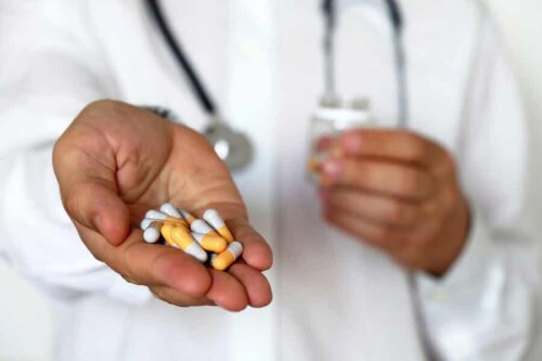 Medico che porge alcune pillole.