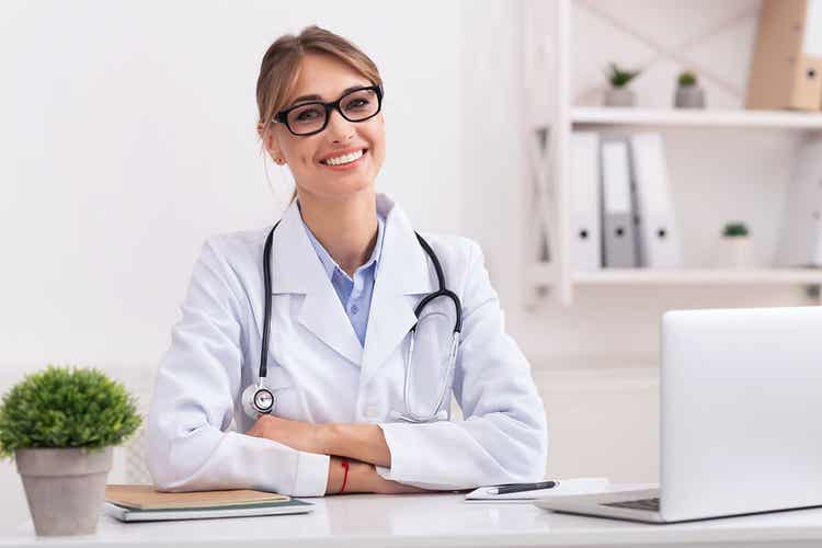 Dottoressa sorridente che parla di ferro e calcio nella donna.