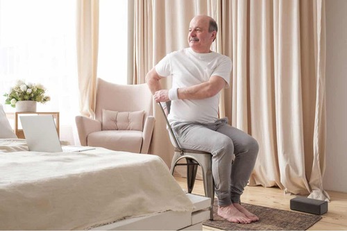 Uomo che fa yoga sulla sedia.