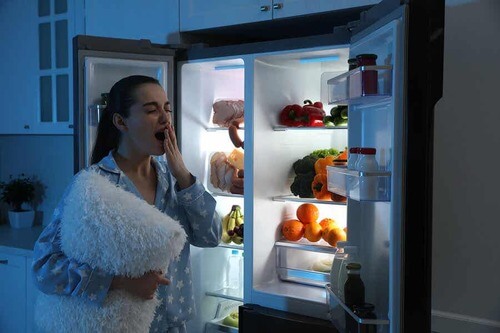 Donna con insonnia davanti il frigo.