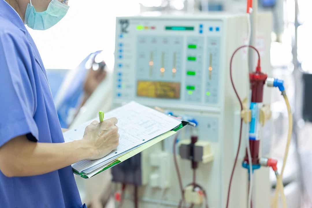 Medico prende appunti su cartella clinica.