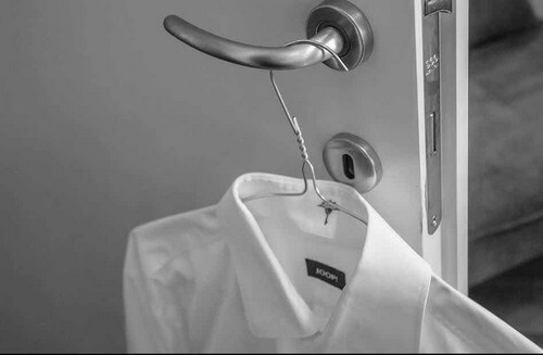 Camicia bianca appesa alla maniglia.