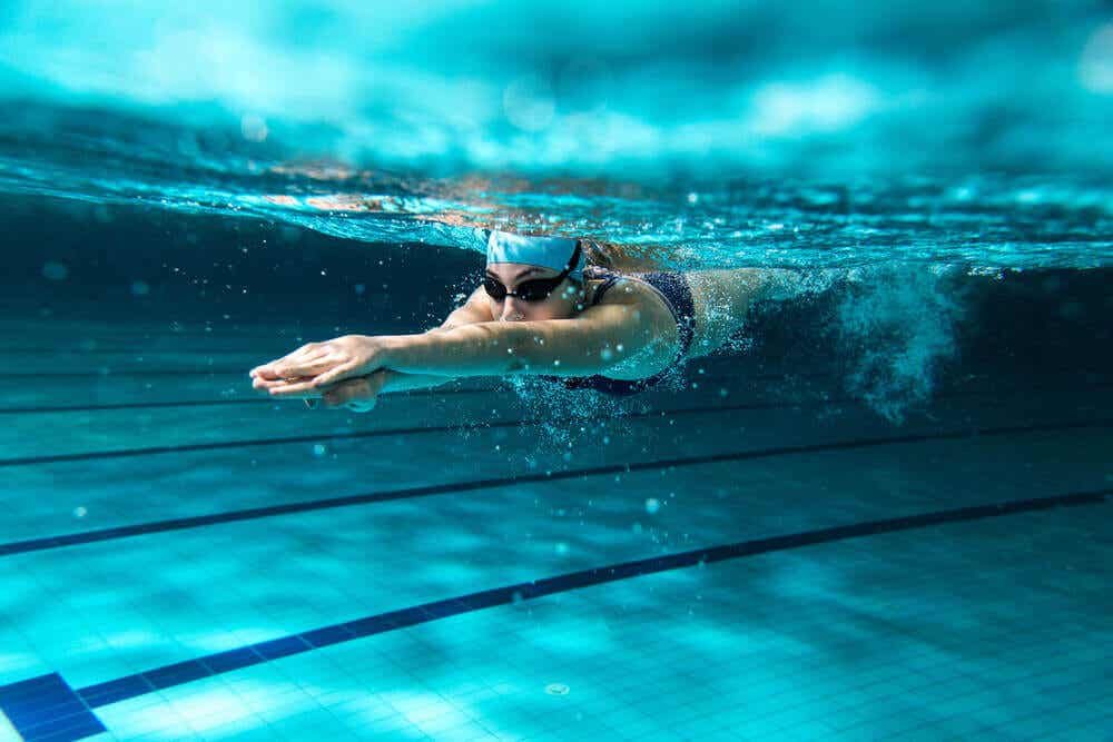 Donna pratica nuoto in piscina.